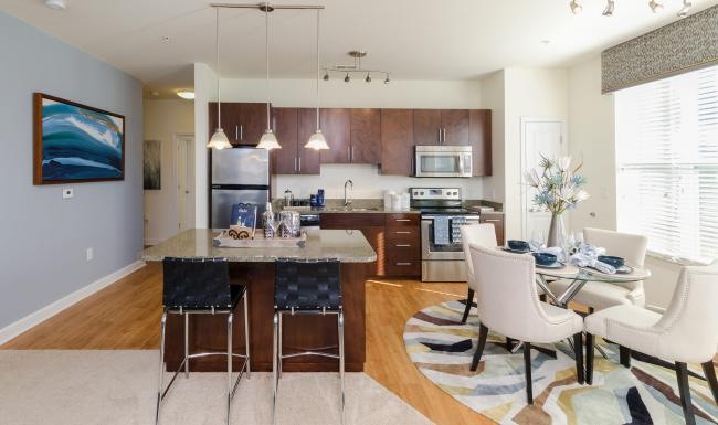 Spacious kitchens with thoughtful details a kitchen with a dining table and chairs